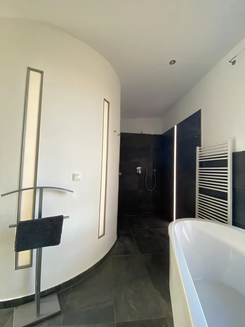 Bad mit ebenerdiger Dusche und freistehender Badewanne