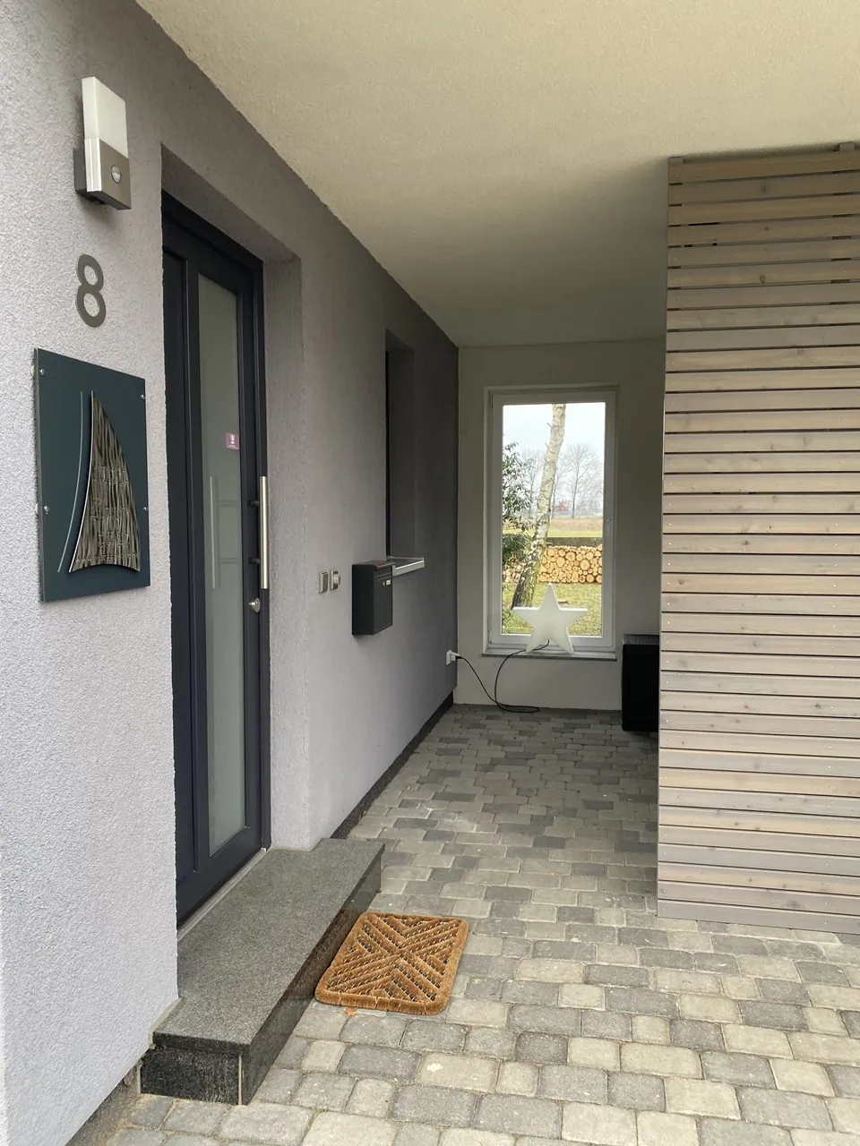 Hauseingang mit Hausnummer 8 und Holzverkleidung
