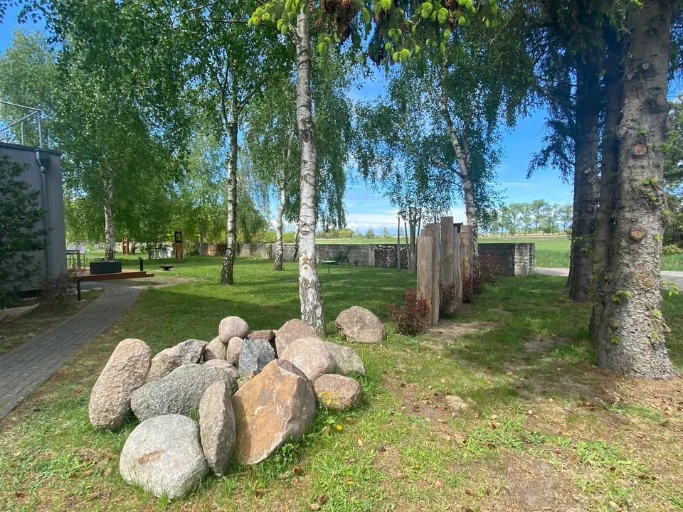 Naturgrundstück mit Findlingen, Birken und Holzstelen