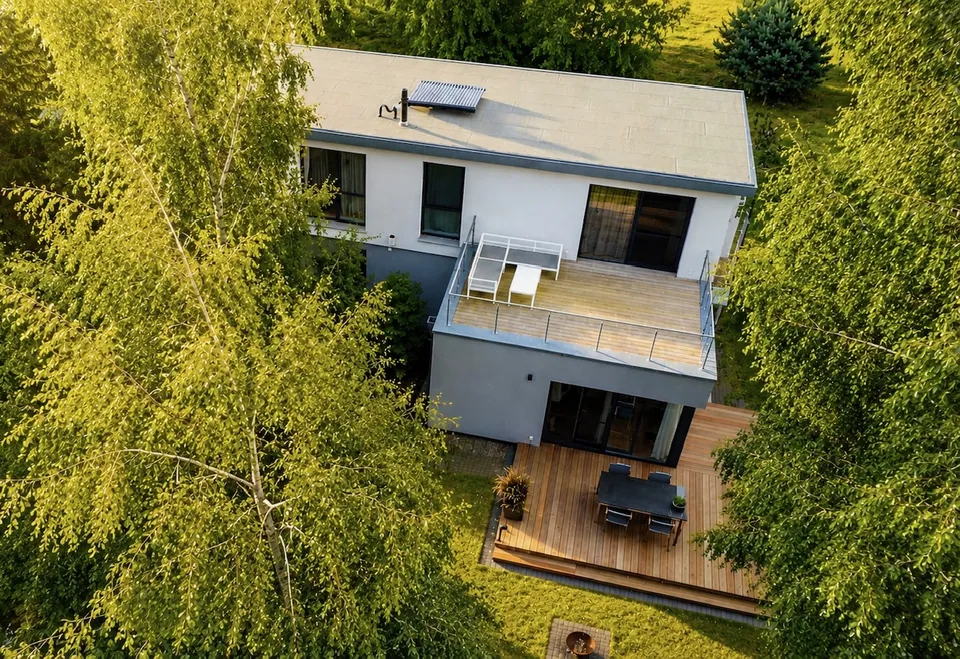 Luftaufnahme des Hauses im Bauhausstil mit Dachterrasse und Holzterrasse