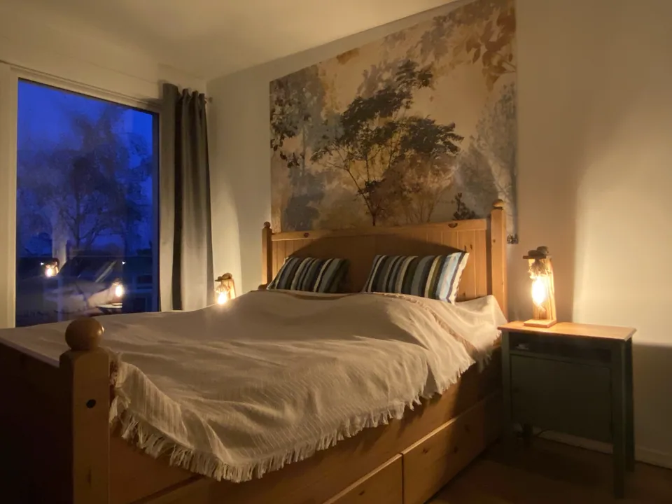 Schlafzimmer mit Holzbett im Abendlicht
